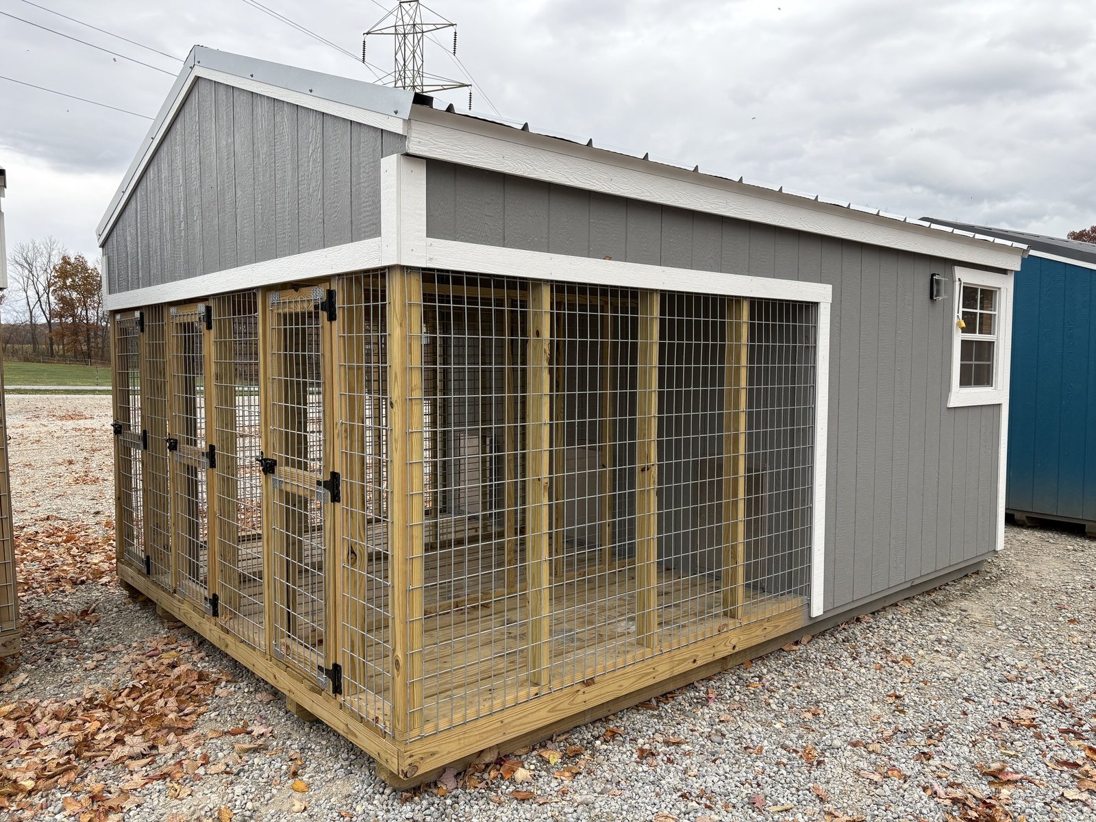 Gray building with a fenced kennel run