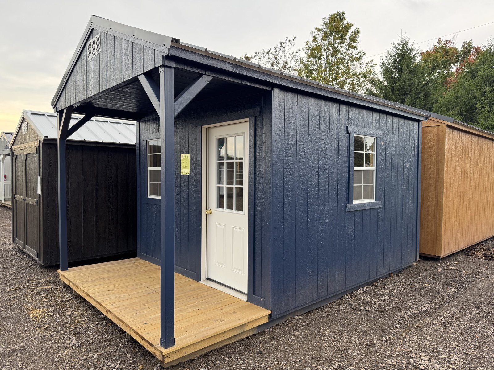 Blue building with a covered porch and white entry door